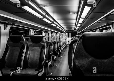 Dover, NJ USA - November 1, 2017:  New double-decker NJ Transit train at night with empty seats, black and white Stock Photo