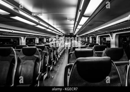 Dover, NJ USA - November 1, 2017:  New double-decker NJ Transit train at night with empty seats, black and white Stock Photo