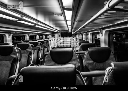 Dover, NJ USA - November 1, 2017:  New double-decker NJ Transit train at night with empty seats, black and white Stock Photo