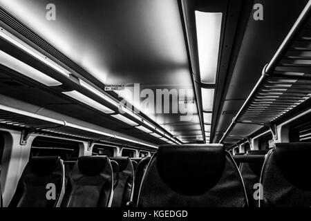 Dover, NJ USA - November 1, 2017:  New double-decker NJ Transit train at night with empty seats, black and white Stock Photo