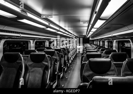 Dover, NJ USA - November 1, 2017:  New double-decker NJ Transit train at night with empty seats, black and white Stock Photo