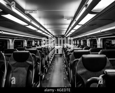 Dover, NJ USA - November 1, 2017:  New double-decker NJ Transit train at night with empty seats, black and white Stock Photo