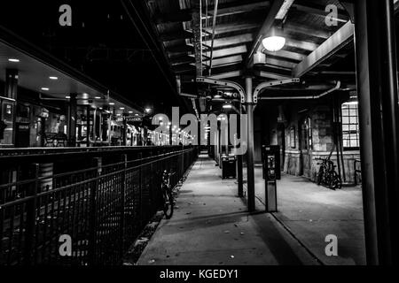 Dover, NJ USA - November 2, 2017:  Bicycles rest along the grungy train station at night, black and white Stock Photo