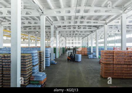 panoramic view of a large warehouse with drinks in plastic bottles with loading machines Stock Photo
