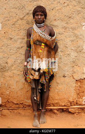 DIMEKA, OMO VALLEY, ETHIOPIA - JULY 26: Portrait of the woman from Hamer people resting by the fence in transit to the local marketplace in Dimeka, Om Stock Photo