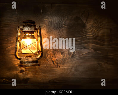 The old kerosene lantern hanging on the wooden wall Stock Photo