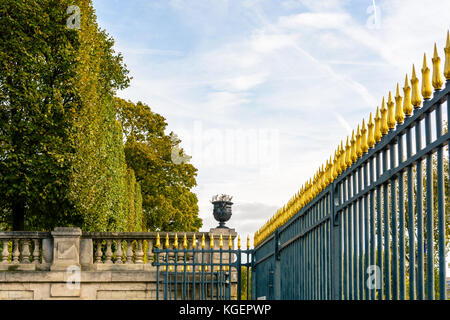 The imposing spiky wrought iron fence of the Tuileries garden in Paris and its golden flower shaped tips. Stock Photo