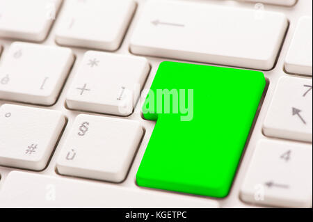 Green button on a white keyboard Stock Photo