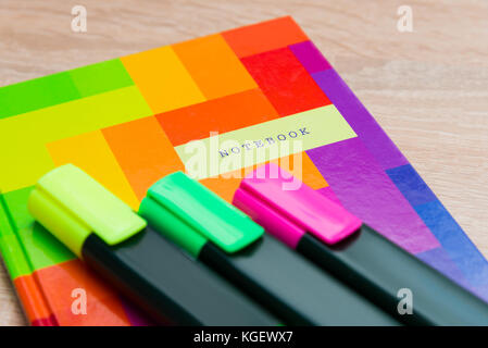 Bright notebook with markers on a wooden background Stock Photo