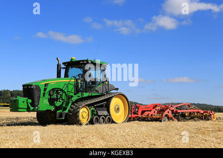 SALO, FINLAND - AUGUST 22, 2015: Unnamed farmer cultivates the field with John Deere 8345RT tracked tractor and Vaderstad cultivator at Puontin Peltop Stock Photo