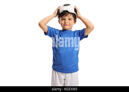 Little footballer holding a deflated football on his head isolated on white background Stock Photo