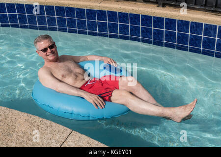 Senior Man Enjoying Resort Swimming Pool, USA Stock Photo