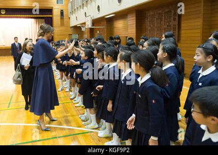 U.S first lady Melania Trump, center, high fives children during a visit to the 4th grade calligraphy class at Kyobashi Tsukiji Elementary School November 6, 2017 in Tokyo, Japan. Trump is on a three-day visit to Japan, the first stop of a 13-day swing through Asia. Stock Photo