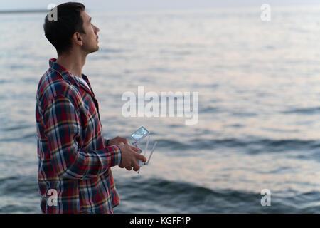 man launches a drone on the beach Stock Photo