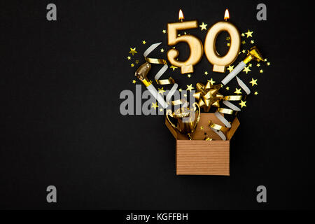 Number 50 gold celebration candle and gift box background Stock Photo