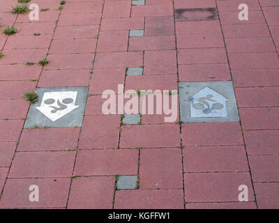 LIEPAJA, LATVIA - AUGUST 23, 2015: For cycling in town are made special pathways from red concrete bricks with original metal driving direction signs. Stock Photo