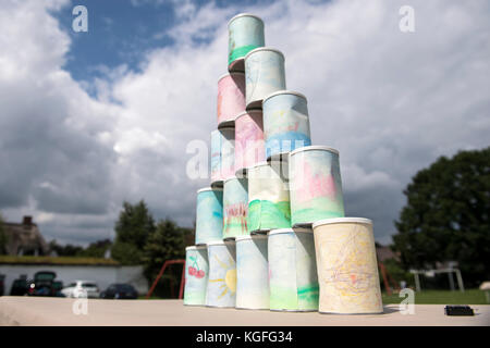 kids throwing a ball at cans Stock Photo