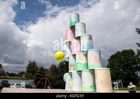 kids throwing a ball at cans Stock Photo