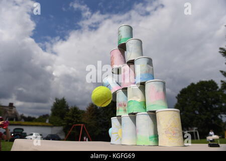 kids throwing a ball at cans Stock Photo