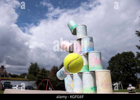 kids throwing a ball at cans Stock Photo