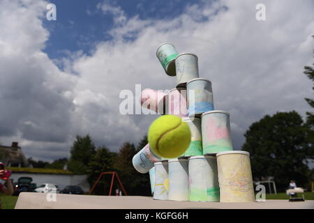 kids throwing a ball at cans Stock Photo