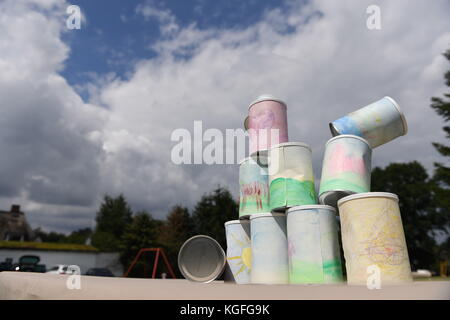 kids throwing a ball at cans Stock Photo