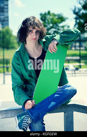 young man skateboarding posing with his skateboard in an urban setting. Stock Photo