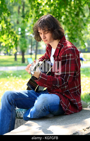 young man playing the guitar, outdoor Stock Photo