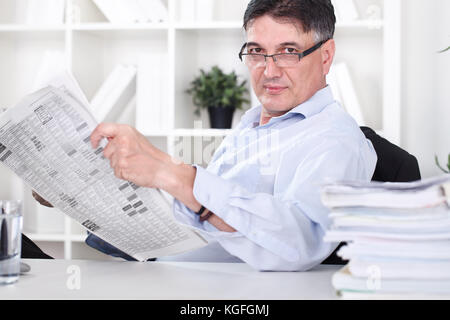 businessman reading the newspaper and having a coffee in office Stock Photo