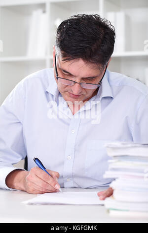 man teacher professor reading concentrated and examine tests Stock Photo