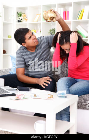 Frustrated young couple calculating their domestic bills at home Stock Photo