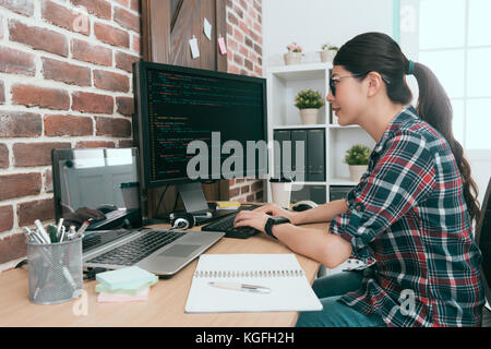 beauty smiling female programmer using computer working in office and typing data code to developing new system protection online user security. Stock Photo