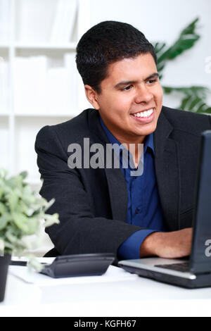 Smiling business man executive using a computer in his office Stock Photo