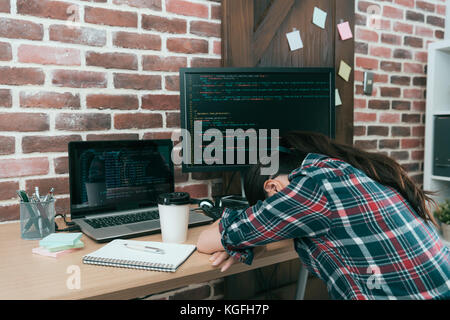 professional young computer engineer woman design code data system  overwork in office feeling tired and sleeping on working desk resting. Stock Photo