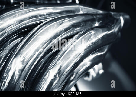 Bent air exhaust pipes. Shiny motor parts, V12 engine fragment, closeup photo with selective focus Stock Photo