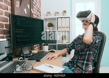 happy beautiful computer engineer woman  working long time in office wearing VR technology device relaxing and enjoying 3D video. Stock Photo