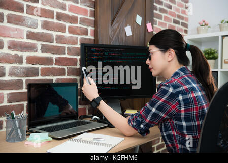 pretty elegant company business woman using mobile cell phone browsing online information system and checking her programming work successful. Stock Photo