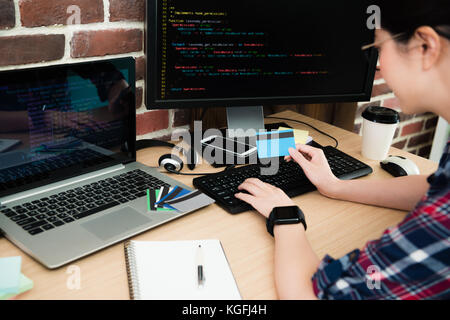 selective focus photo of young pretty female programmer using code language designing online safety system to protect credit card personal information Stock Photo