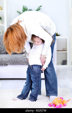 laughing mother dressing stockings her little girl Stock Photo