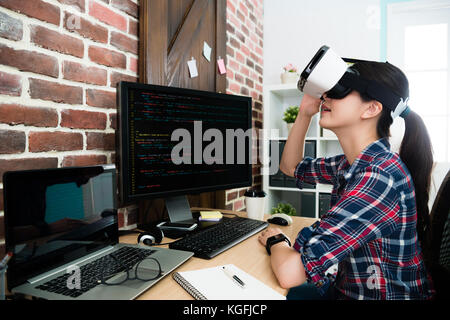 elegant pretty business woman working on programming company and wearing VR device glasses viewing 3D code language design plan. Stock Photo