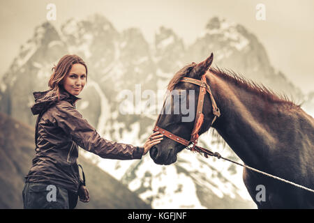 Portrait of young pretty cheerful woman with horse Stock Photo