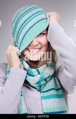 smiling funny girl pulling her winter hat Stock Photo