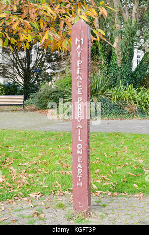 Wooden post with wording "May peace prevail on earth" in sensory garden near Plymouth Hoe, Devon Stock Photo