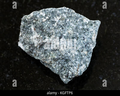 macro shooting of natural mineral rock specimen - rough Diorite stone on dark granite background Stock Photo