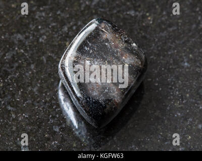 macro shooting of natural mineral rock specimen - polished anthophyllite gemstone on dark granite background from Tirol, Austria Stock Photo