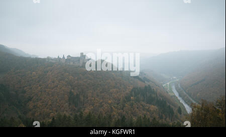 Bourscheid castle in the fog. Old fortress on a hill in Luxembourg. Autumn colors. Stock Photo