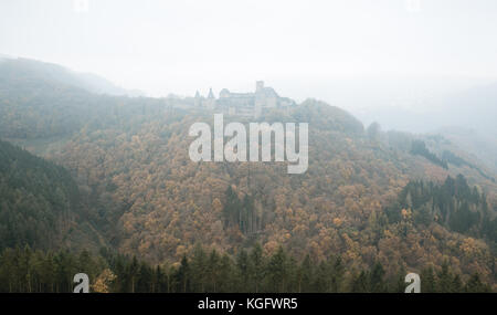 Bourscheid castle in the fog. Old fortress on a hill in Luxembourg. Autumn colors. Stock Photo