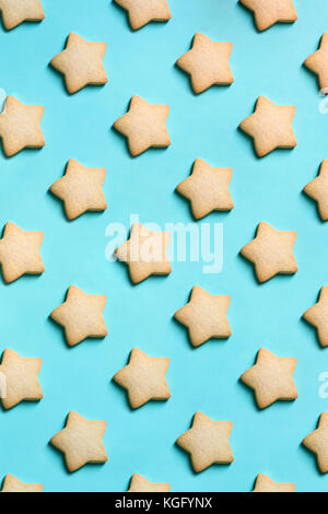 Bakery pattern. Star shaped Christmas cookies on turquoise background. Winter cooking theme. Top view, flat lay. Stock Photo