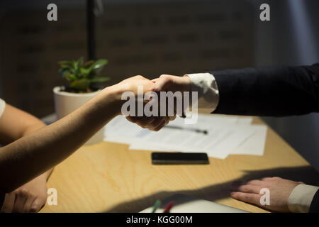 Two businesspeople shake hands to seal a deal, recruiter employing new staff member, human resources manager shaking hands with job candidate after in Stock Photo