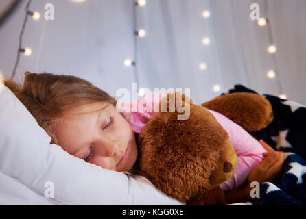 Girl sleeping with teddy bear in her bedroom Stock Photo